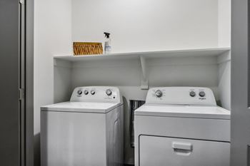 A small laundry room with two washes and a dryer